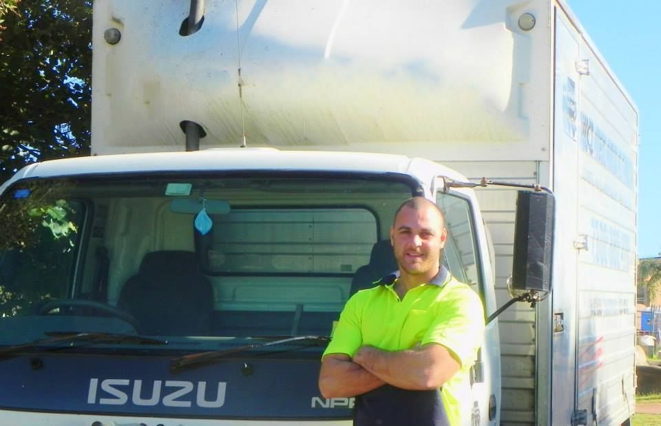 Man Standing with Arms Crossed in Front of A White Isuzu Truck — MM Removals In Nelson Bay, NSW