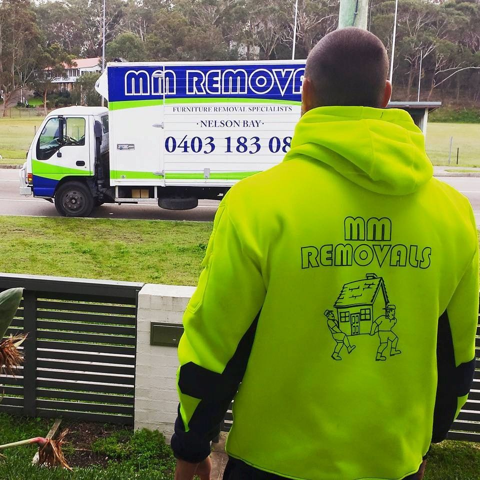 Person in Neon Green Hoodie Watching a Moving Truck Parked in A Grassy Park Area — MM Removals In Nelson Bay, NSW