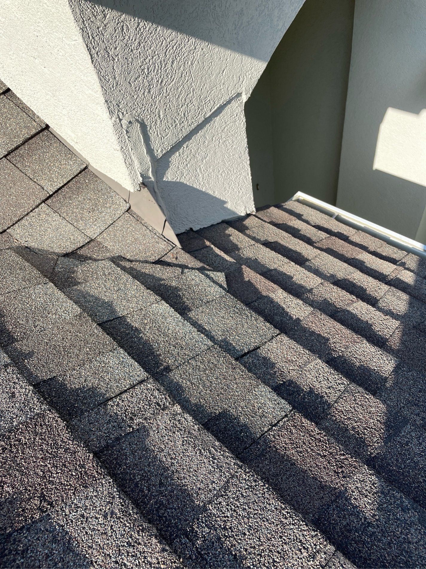 Sunlit concrete stairwell with dark striped shadows cast across gray steps and walls