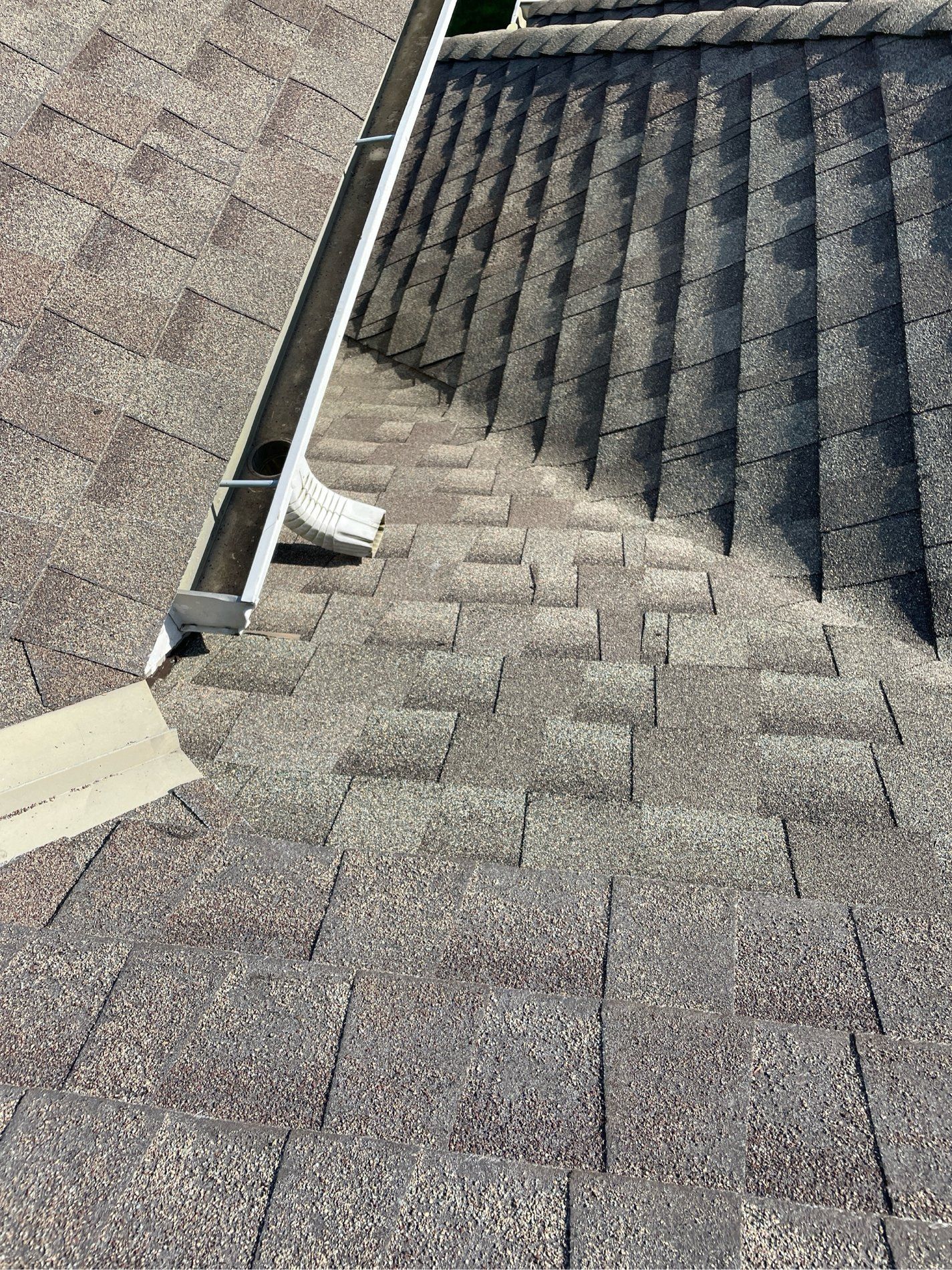 Roof shingles with a metal gutter and flashing at a roof valley