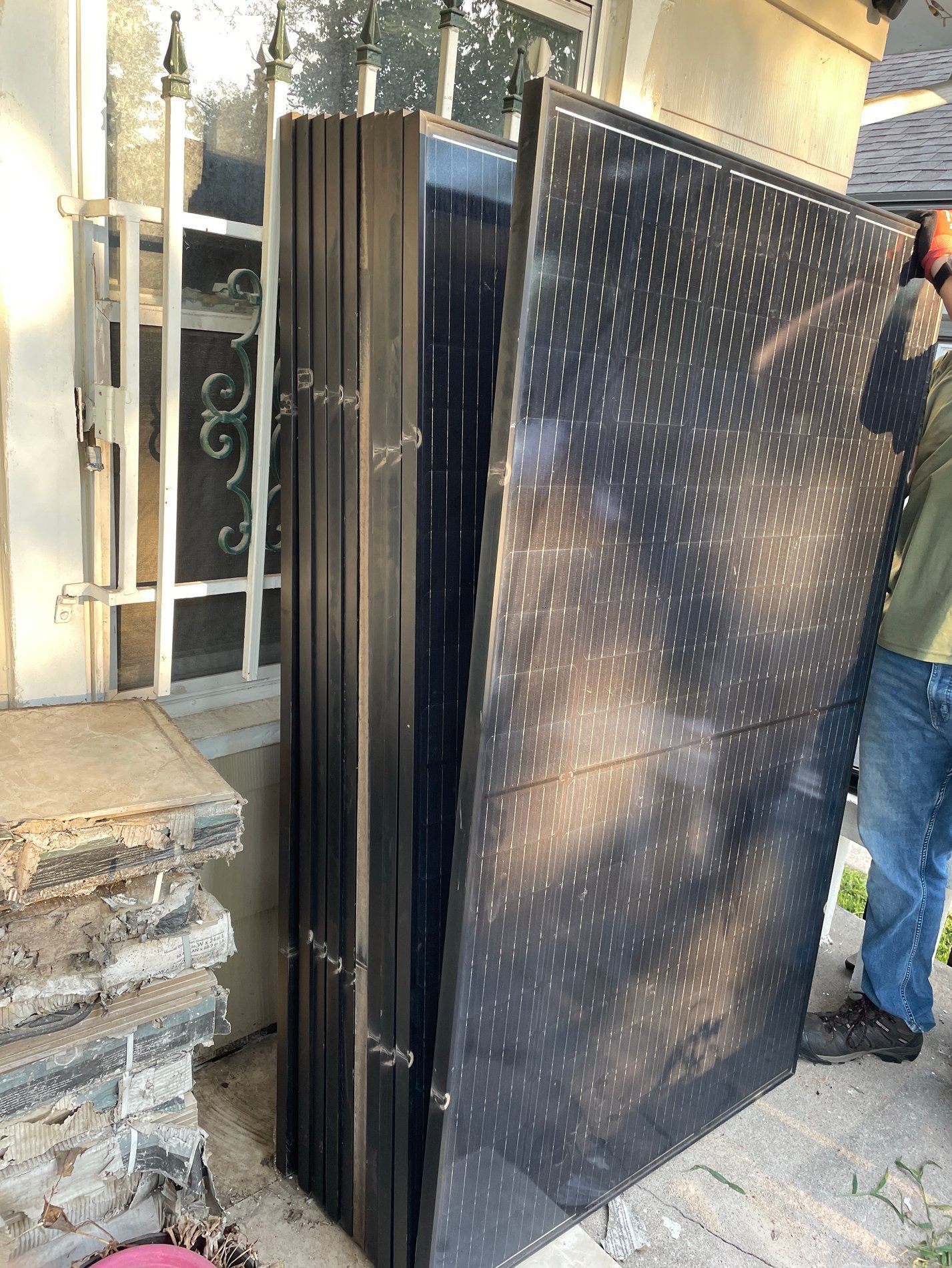 Tall black folded panel with white dot pattern being carried outdoors by a person near a doorway