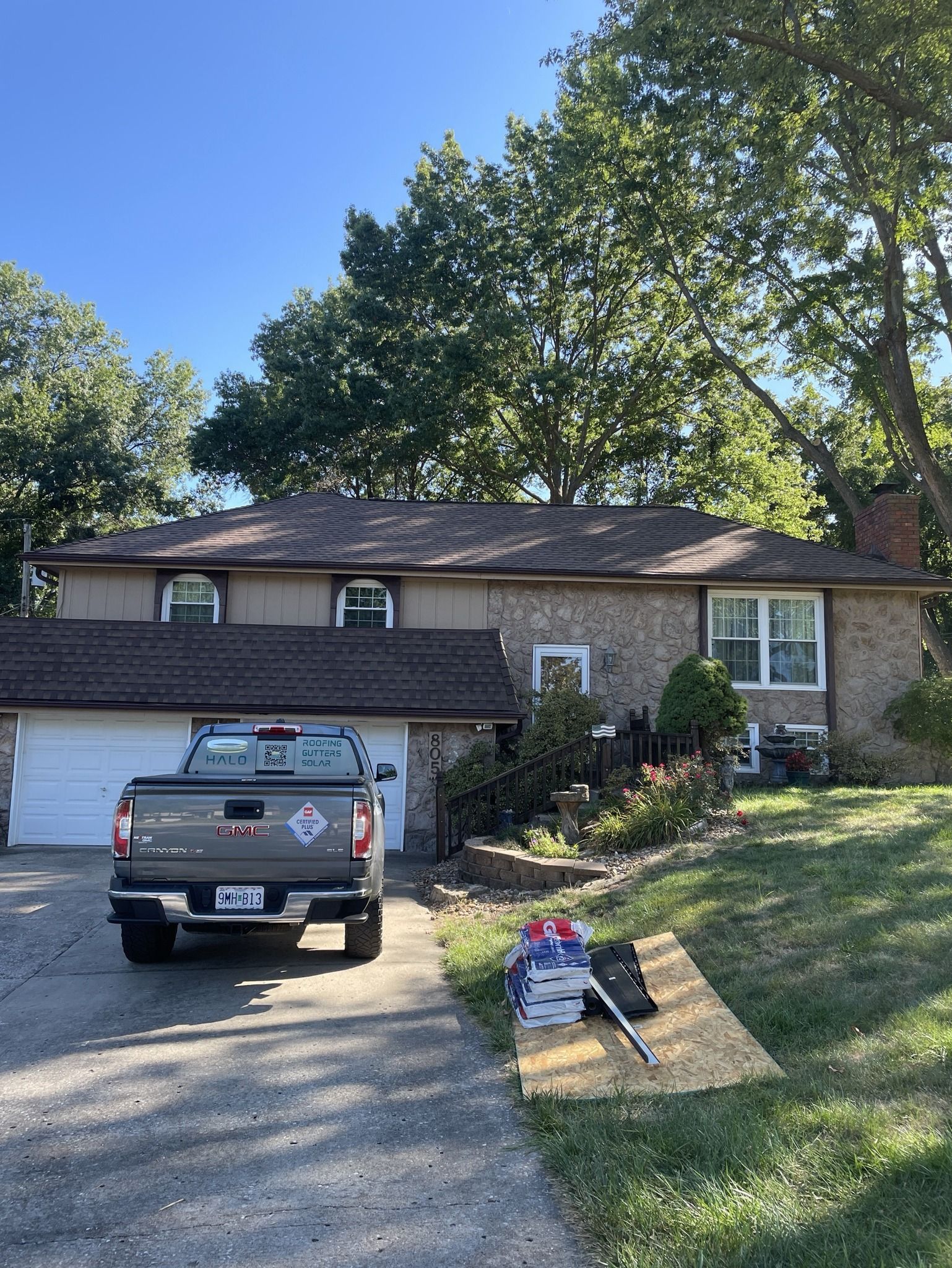 Suburban house with garage and pickup truck in driveway under a clear blue sky