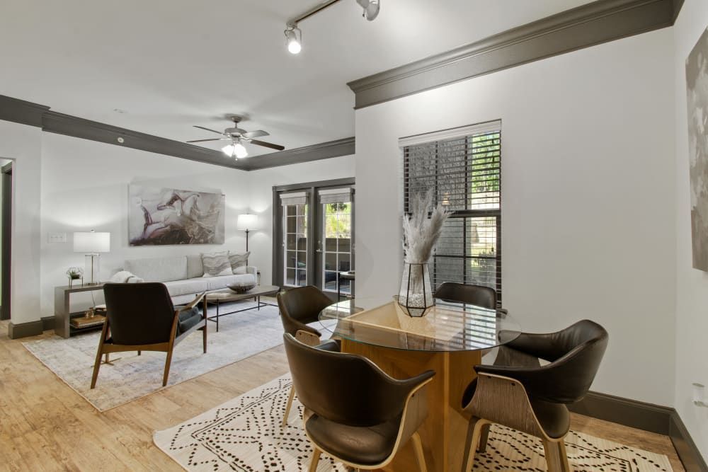 a living room with a dining table and chairs and a ceiling fan at Marquis on Evans in San Antonio, TX.