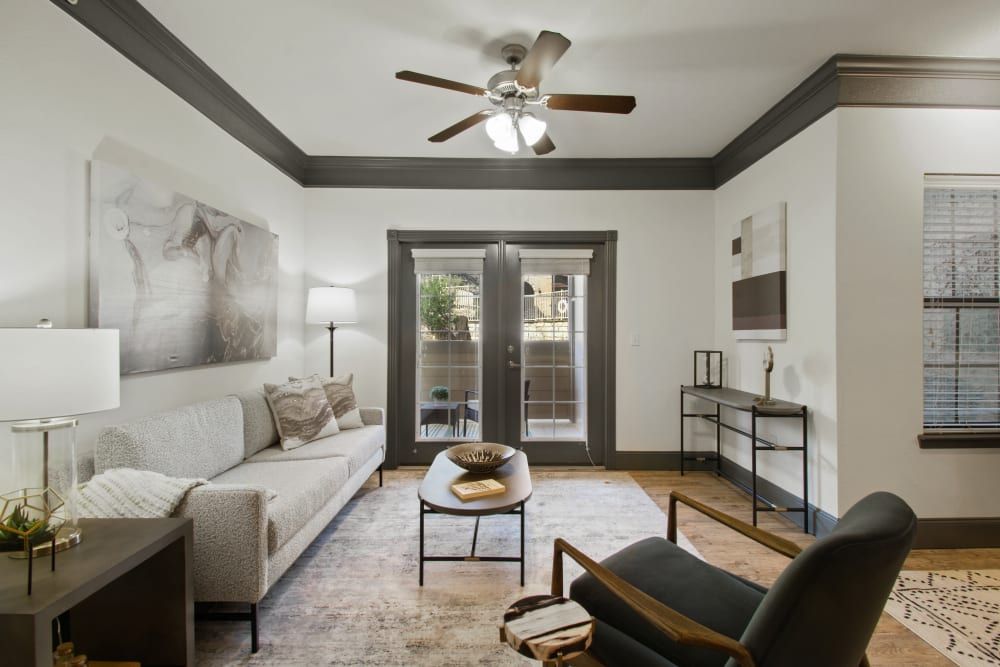 a living room with a couch, chair, coffee table, and ceiling fan at Marquis on Evans in San Antonio, TX.