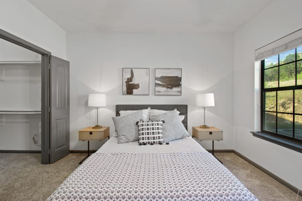 a bedroom with a bed, nightstands, lamps, and a window at Marquis on Evans in San Antonio, TX.