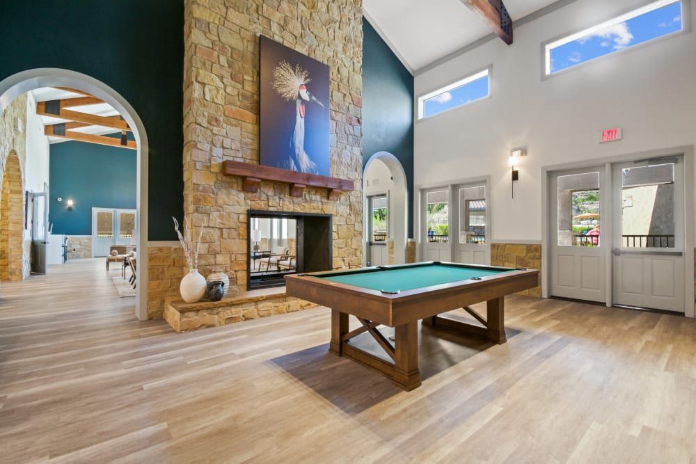 there is a pool table in the middle of the room at Marquis on Evans in San Antonio, TX.