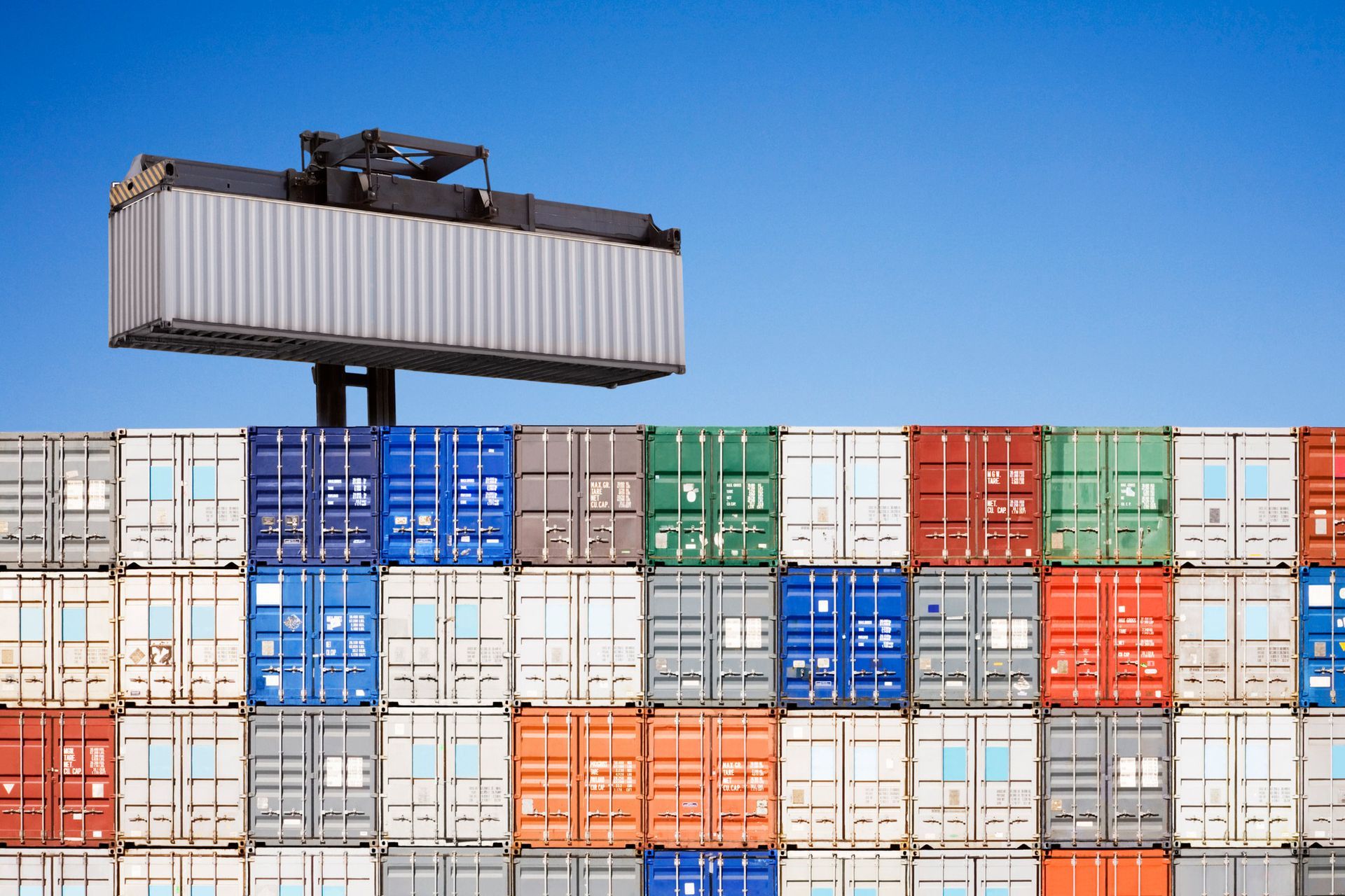 A stack of shipping containers with a crane on top of them.