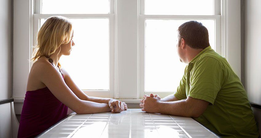 man and woman sitting across a table
