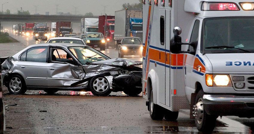 ambulance with crashed car in the background