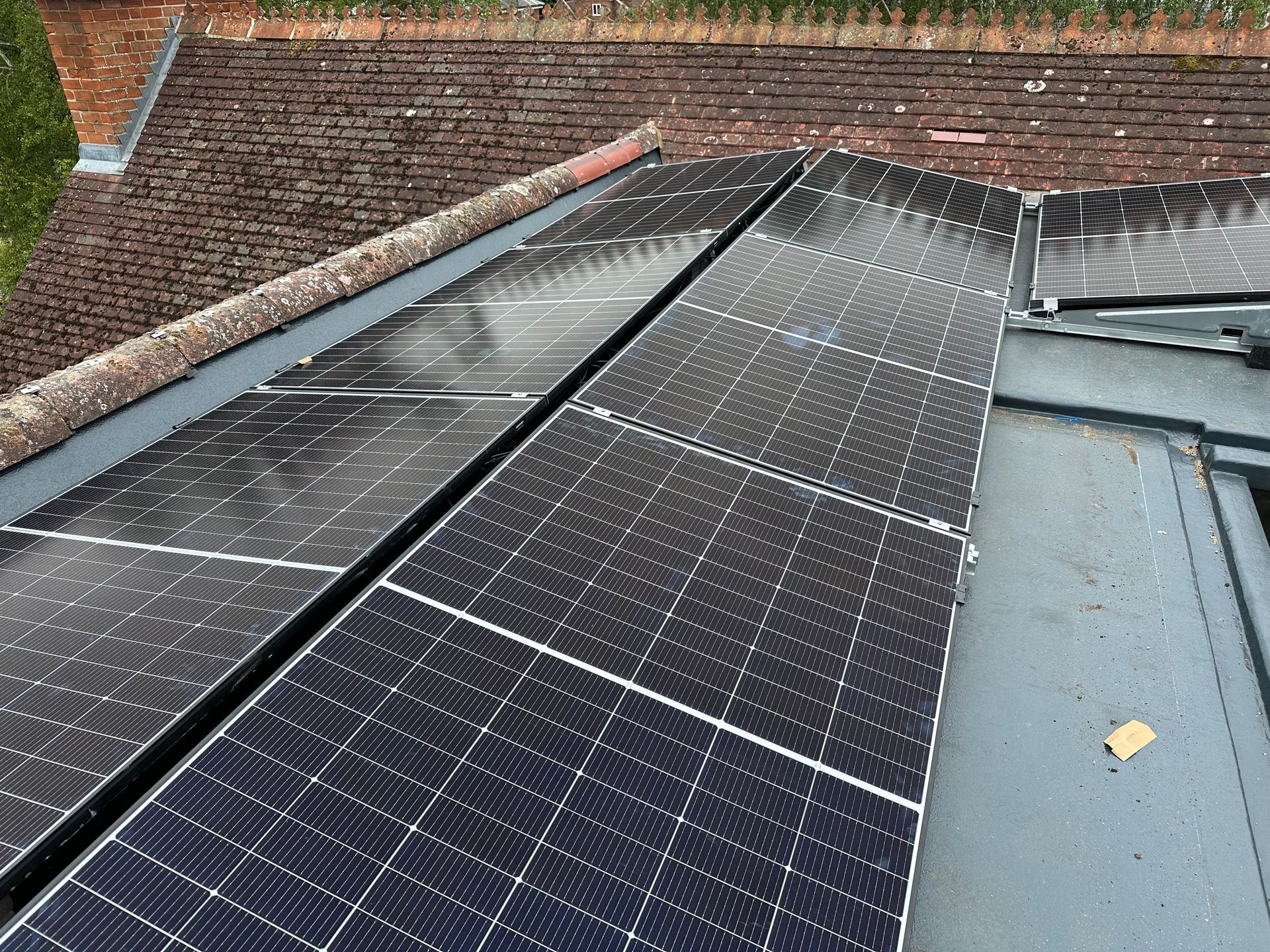 Solar panels fitted on the flat roof and gable wall of a renovated home near Iffley