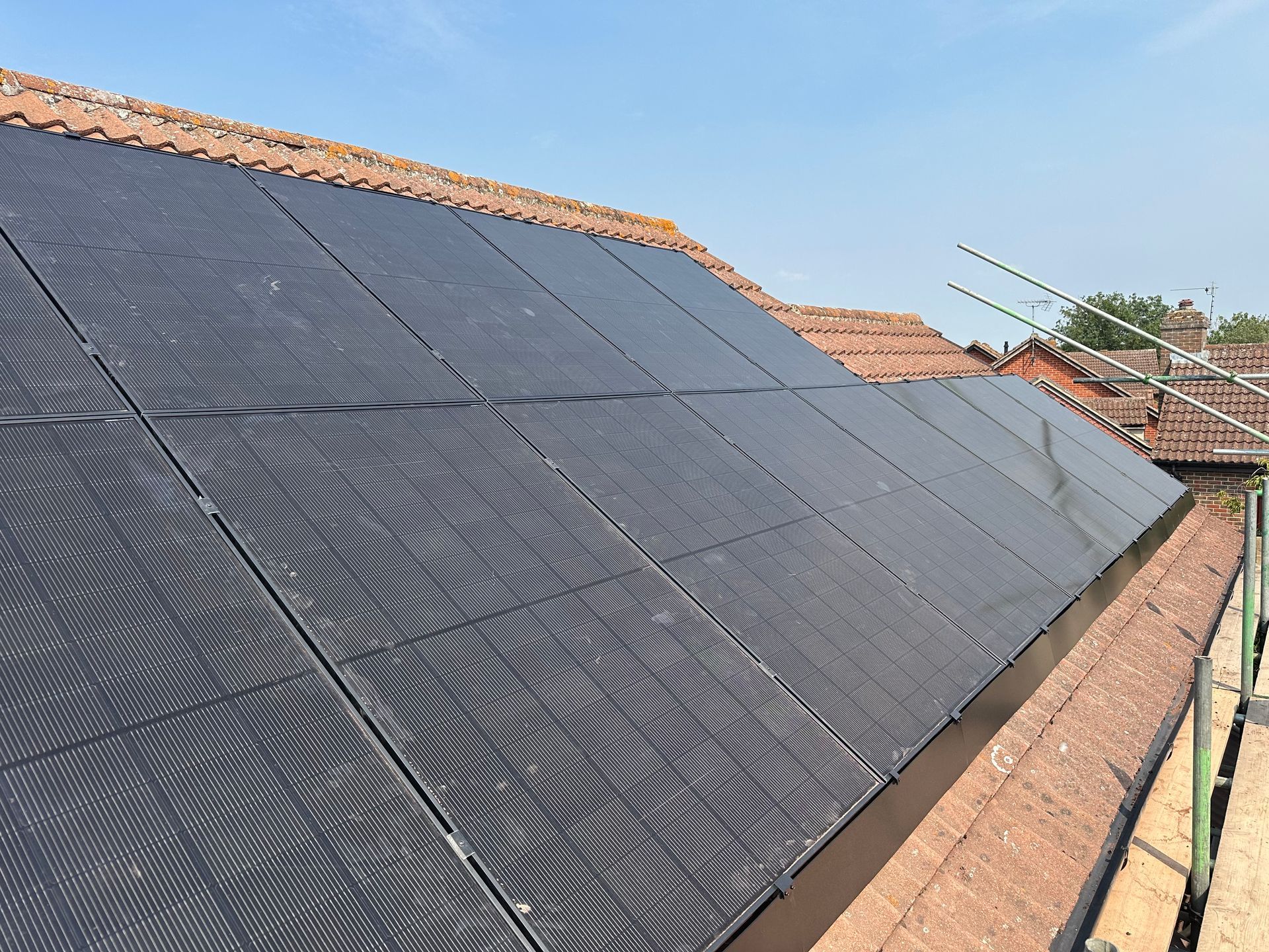Solar panels fitted on the flat roof and gable wall of a renovated home near Iffley