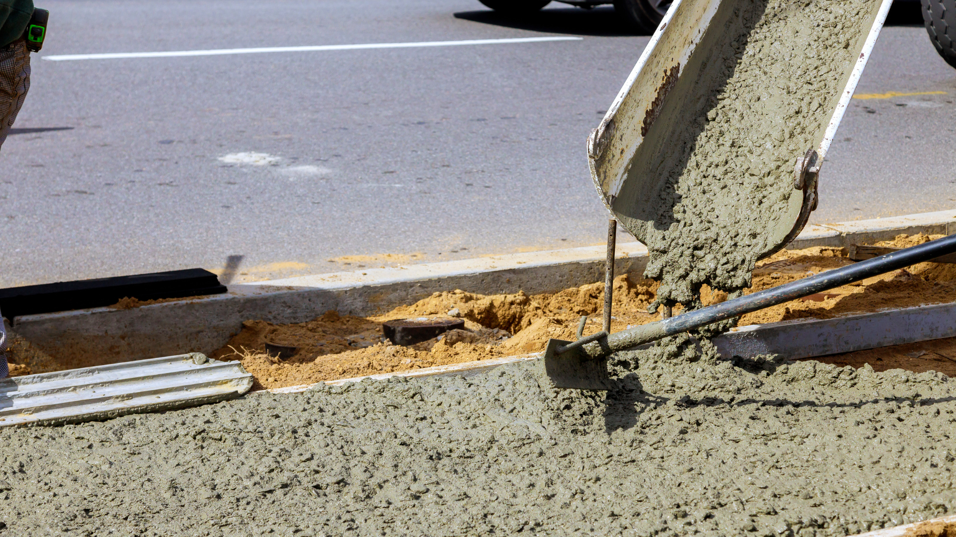 Workers installing rebar reinforcement inside concrete driveway forms
