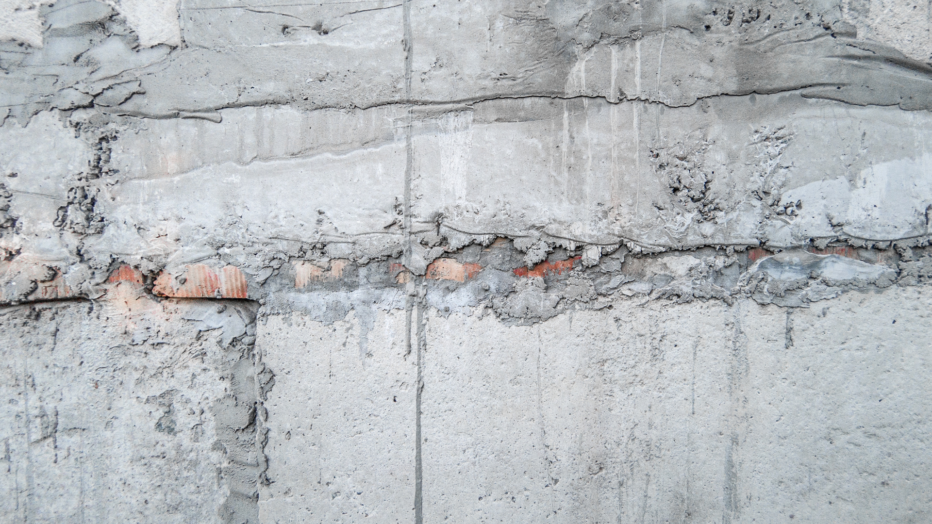 Technician inspecting basement crack repair before waterproofing process