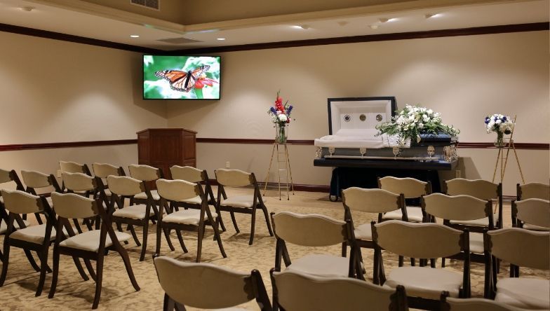 a room with rows of chairs and a television on the wall .