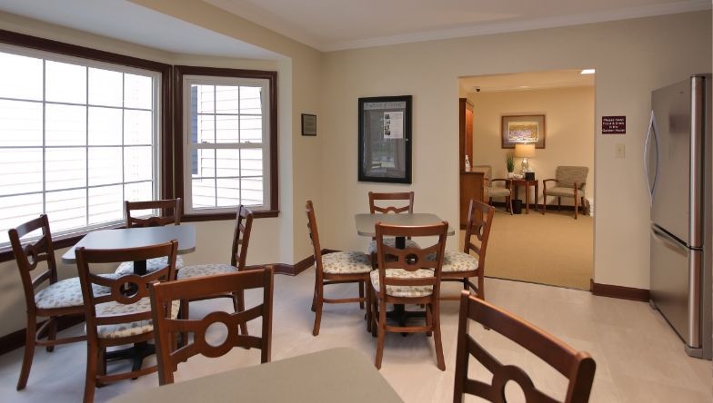 a room with tables and chairs and a refrigerator