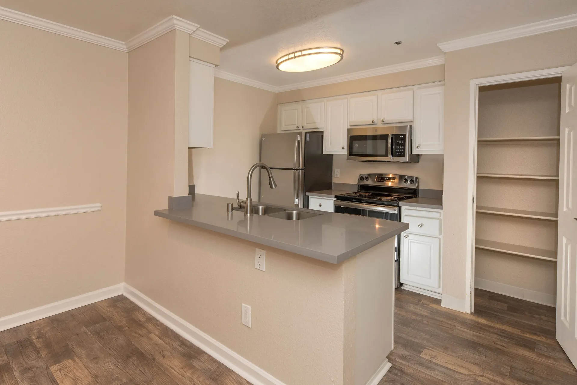 Kitchen with island, stainless-steel appliances, white cabinets at Sterling Heights apartments in Benicia, CA.