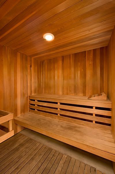 Wood-paneled indoor sauna with built-in benches and a ceiling light at Sterling Heights apartments in Benicia, CA.