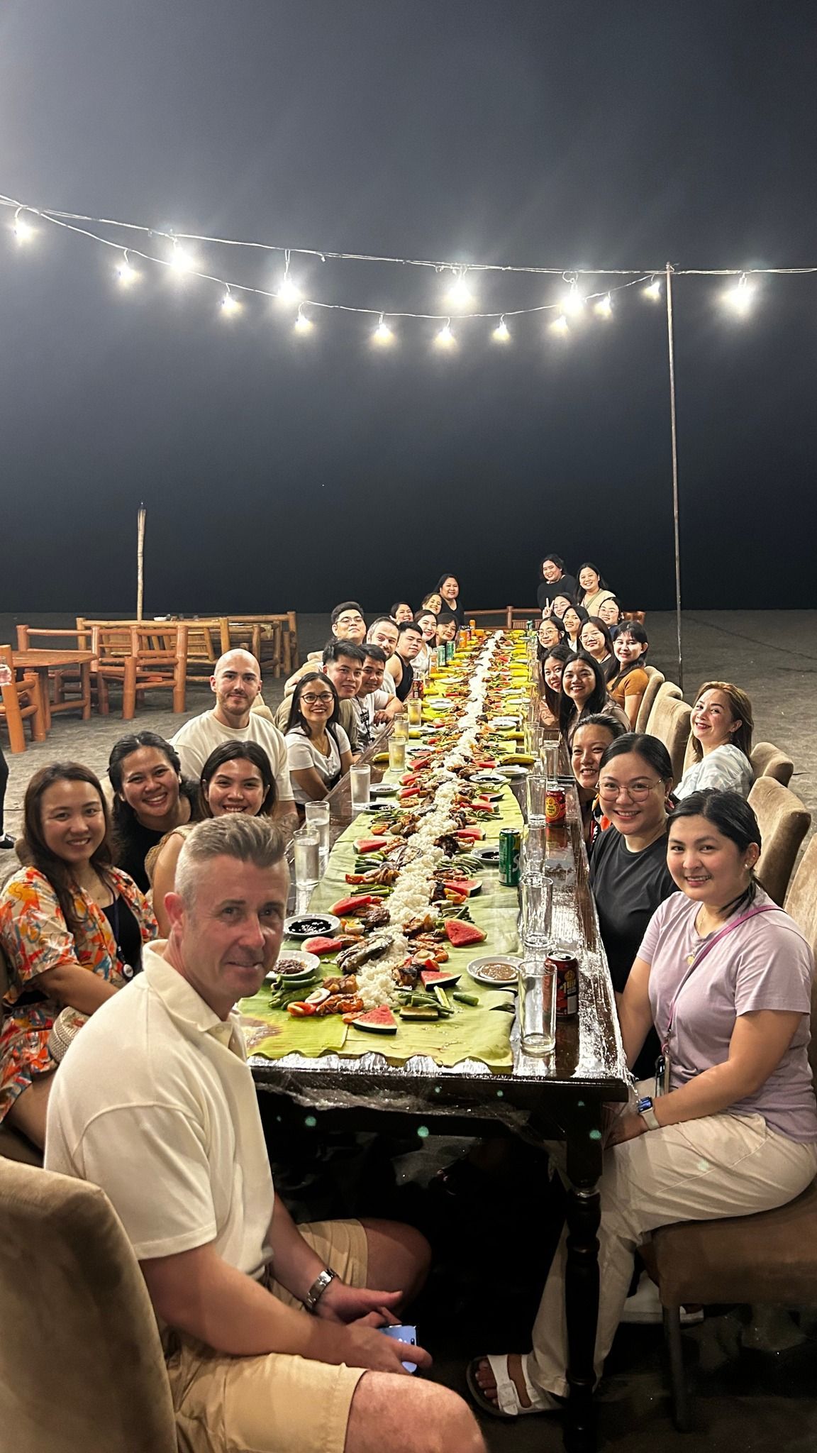 A group of people are sitting around a long table.