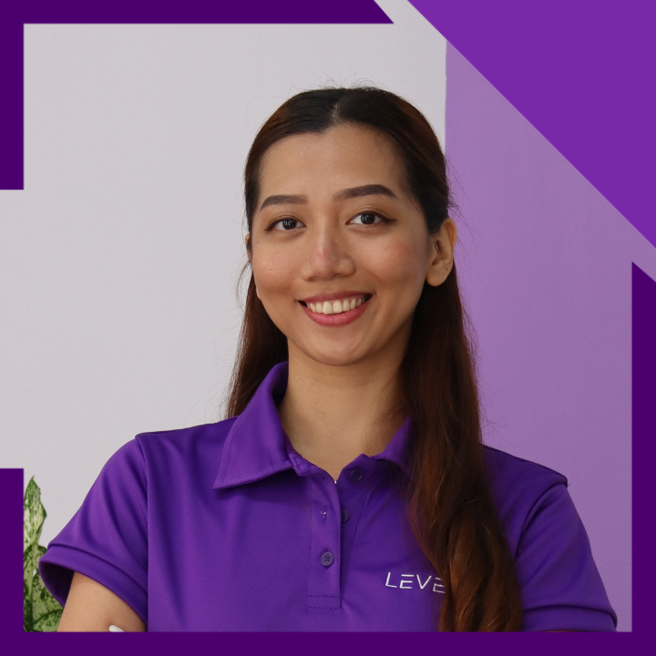 A woman wearing a purple shirt with the word leve on it