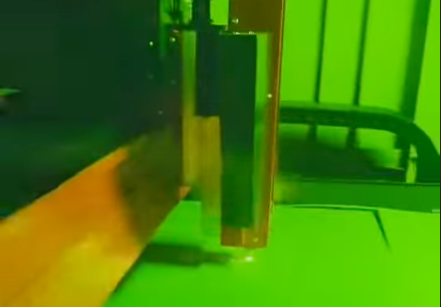Green-tinted close-up of a metal latch beside a chair or rail on a surface