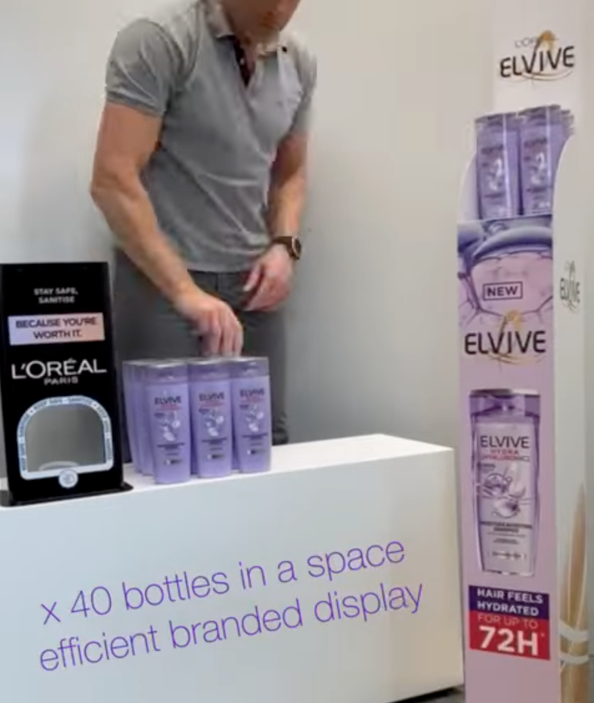 L’Oréal Elvive purple shampoo display with bottles and a man setting up a branded booth