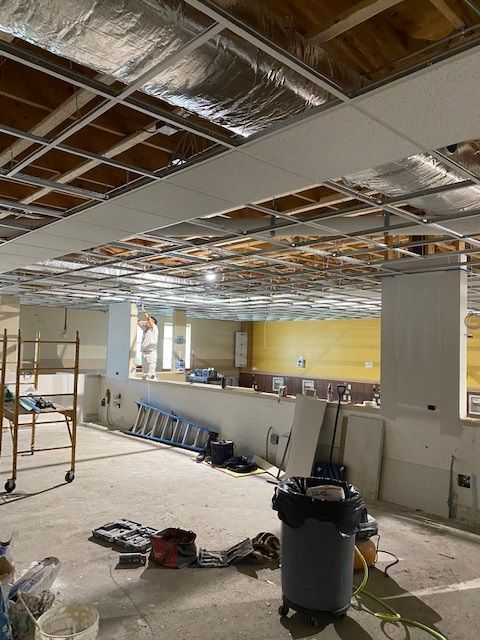 A room under construction with a vacuum cleaner in the middle
