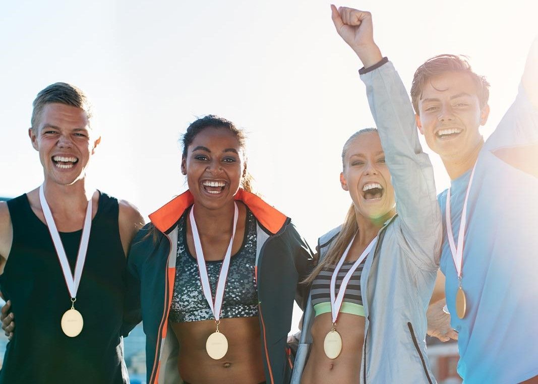 A group of young people wearing medals are posing for a picture.