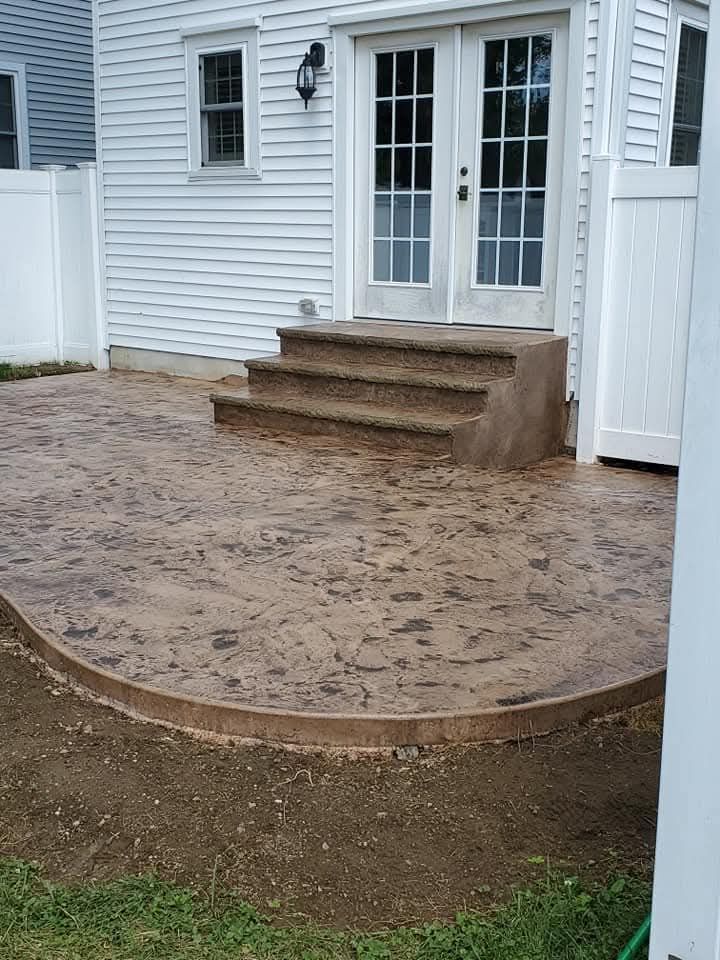 Backyard patio area with three concrete steps leading to white French doors on a house