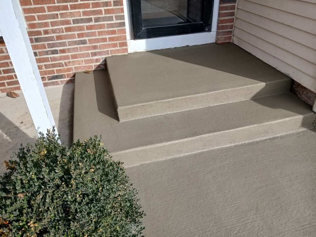 Front porch with beige carpeted steps leading to a white door beside brick and siding exterior.
