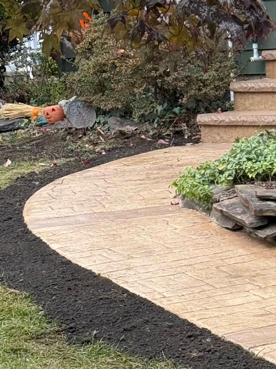 Curved stone walkway beside dark mulch and shrubs in a landscaped garden