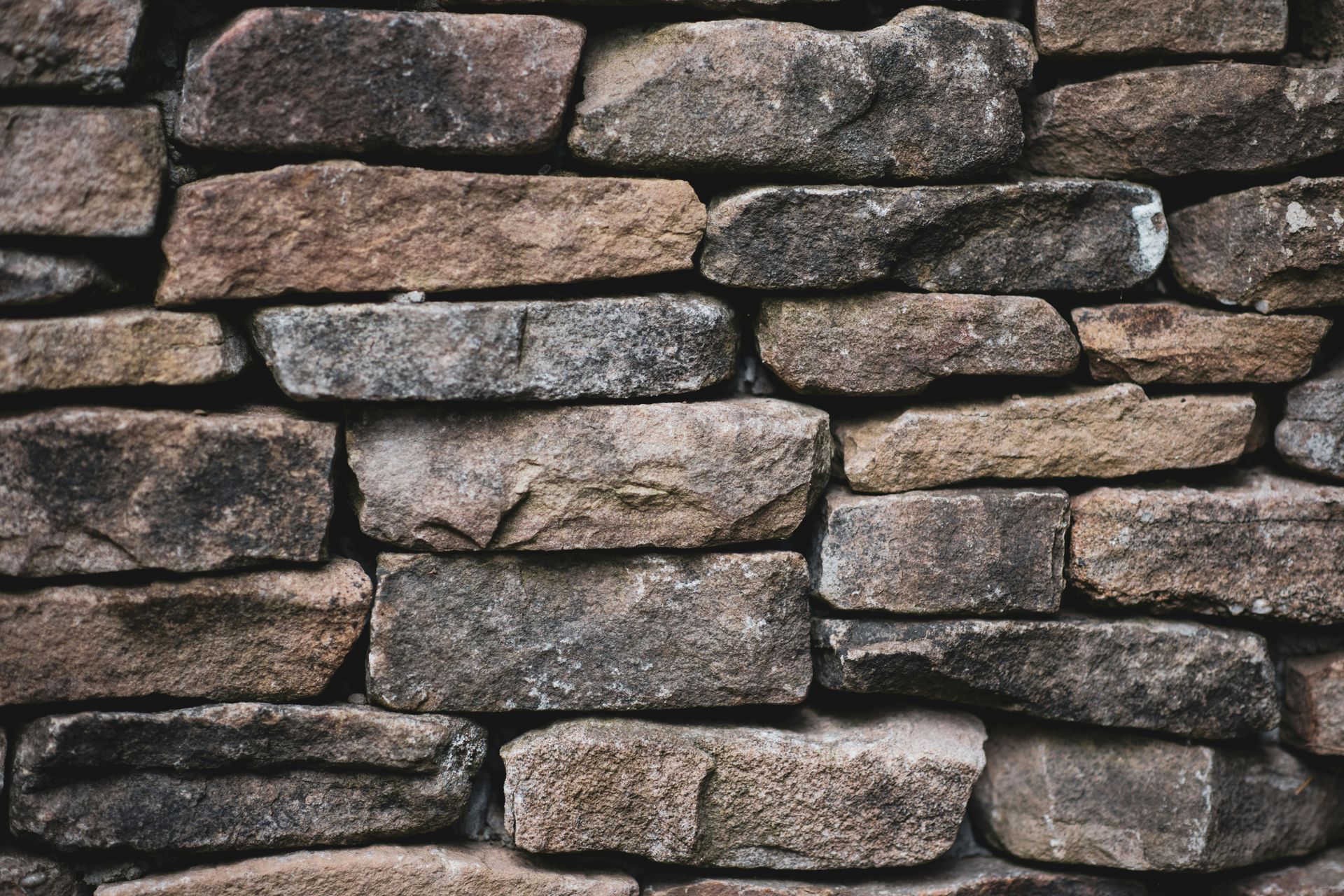 Stacked rough stone wall with gray and brown rocks