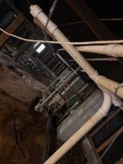 Industrial pipes and metal framework in a dim underground utility tunnel