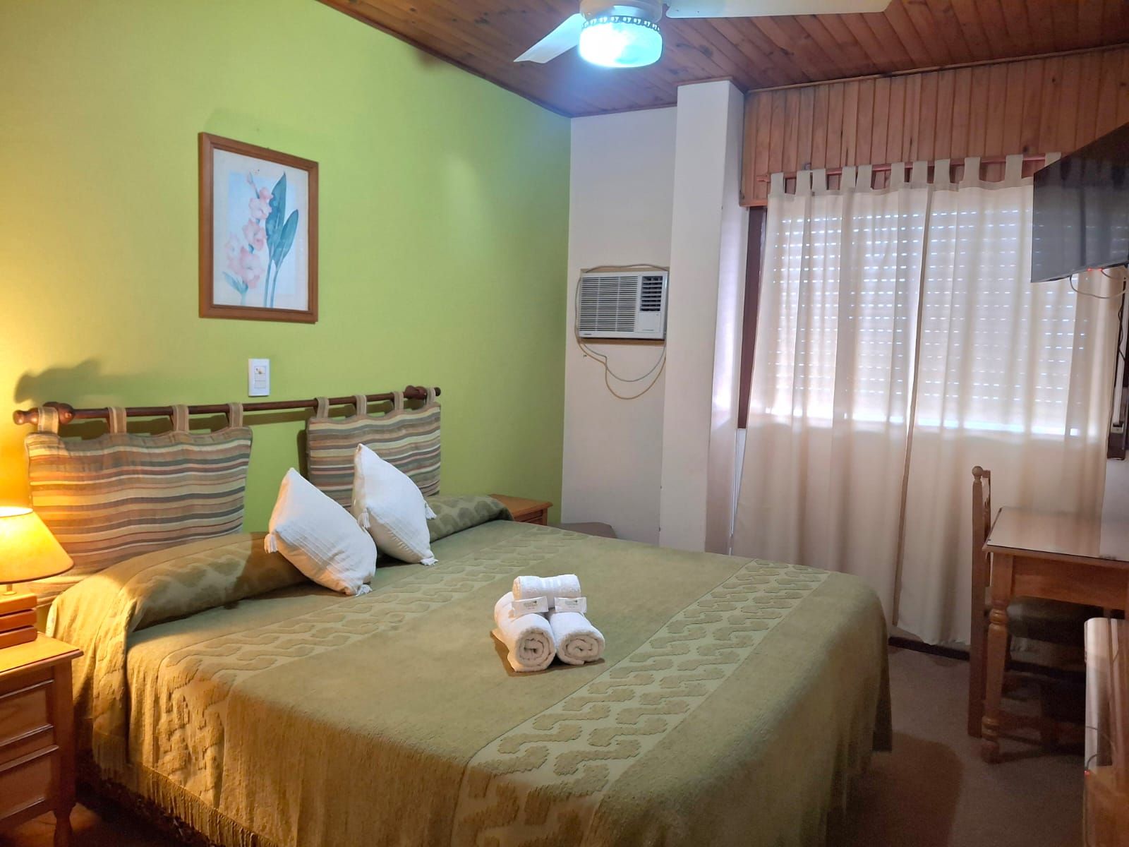 Dos camas individuales en una acogedora habitación de hotel con lámparas cálidas y una cortina en la ventana.