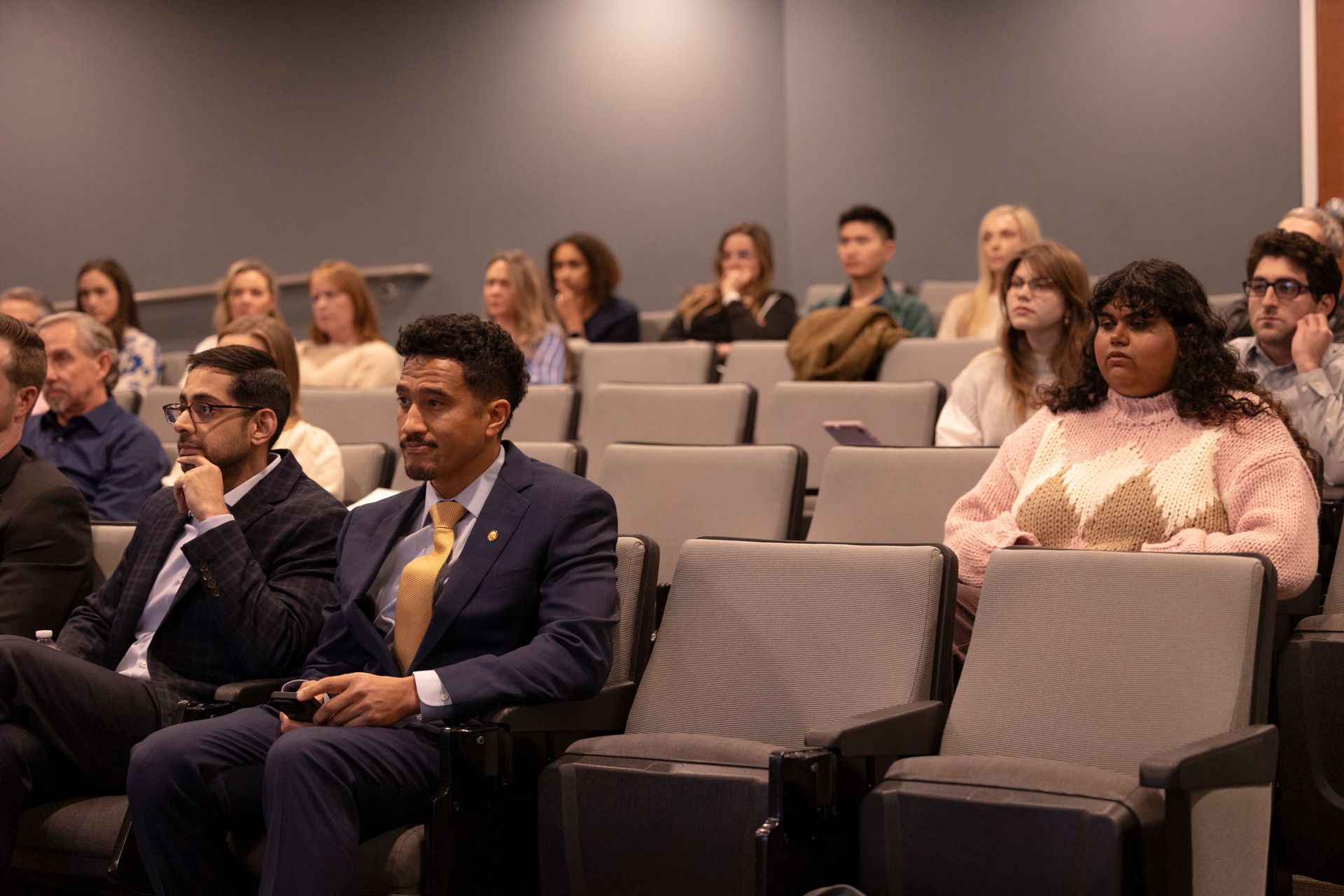 A group of people are sitting in a lecture hall.