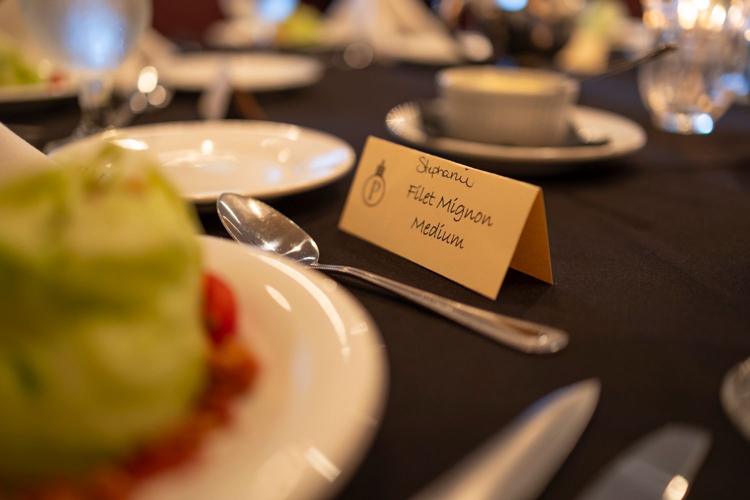 A table with plates , utensils , and a name tag that says felicia