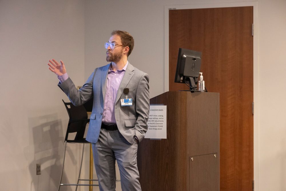 A man in a suit is giving a presentation in front of a podium.