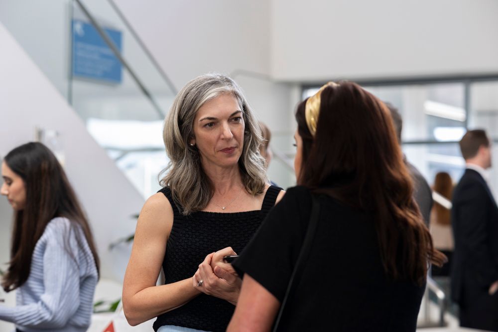 Two women are talking to each other in a room.