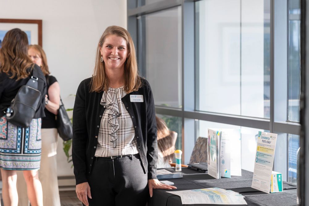 A woman is standing in front of a table in a room.