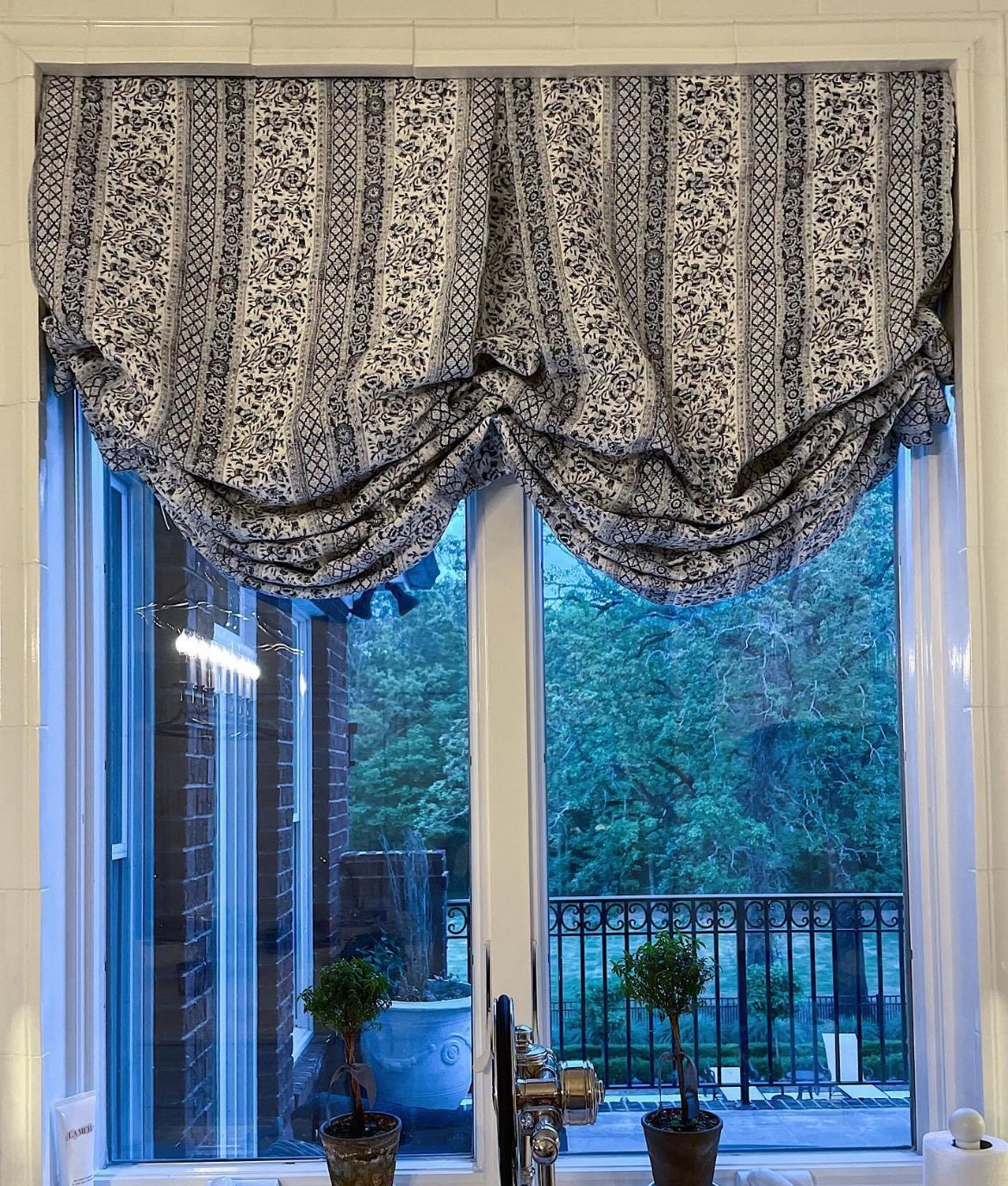 A window with two potted plants in front of it