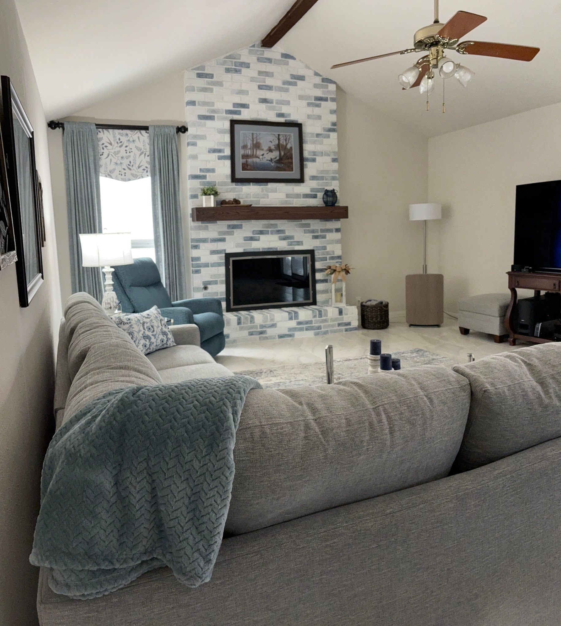 A living room with a fireplace and a ceiling fan