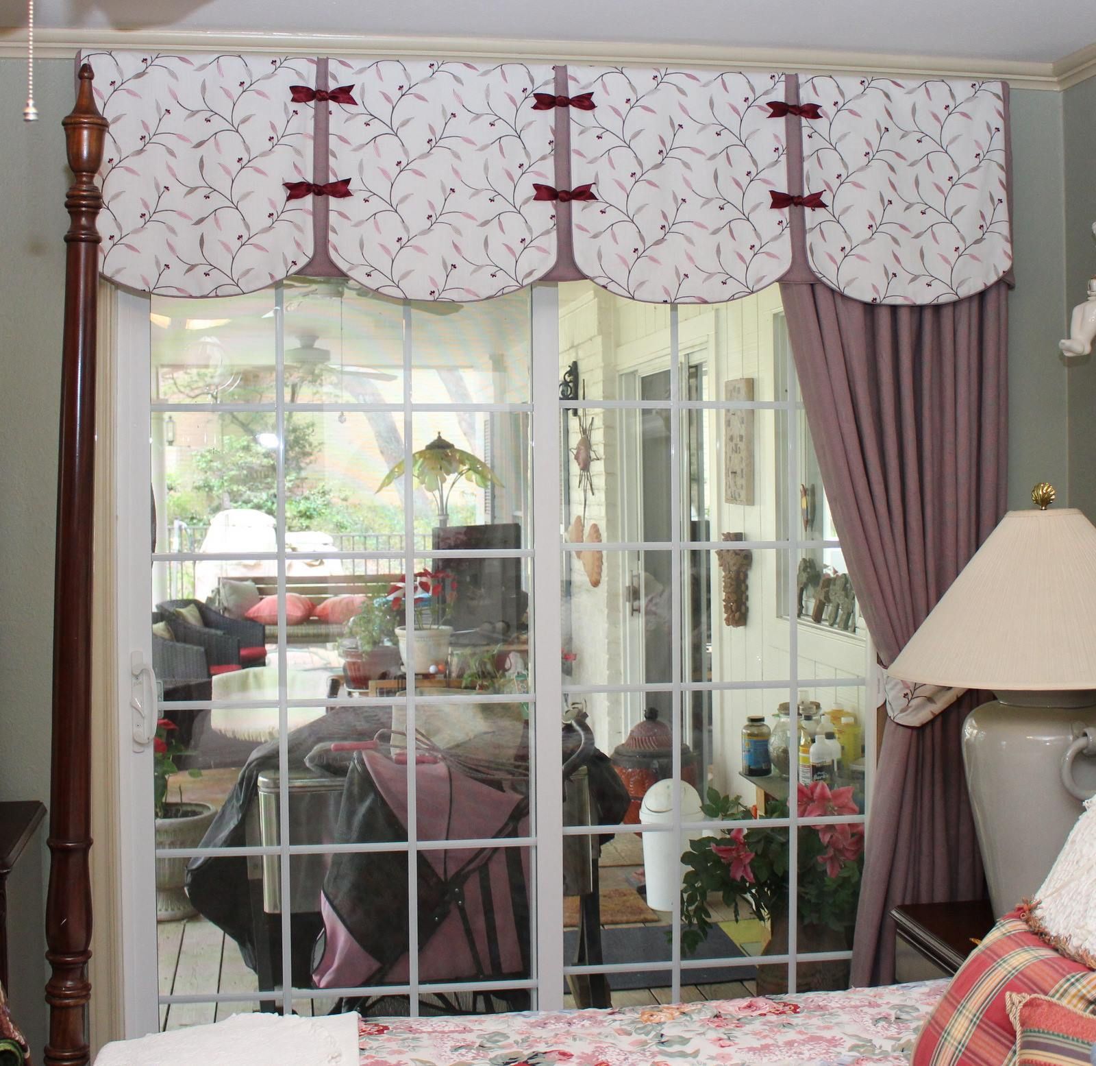 A bedroom with a four poster bed and a sliding glass door