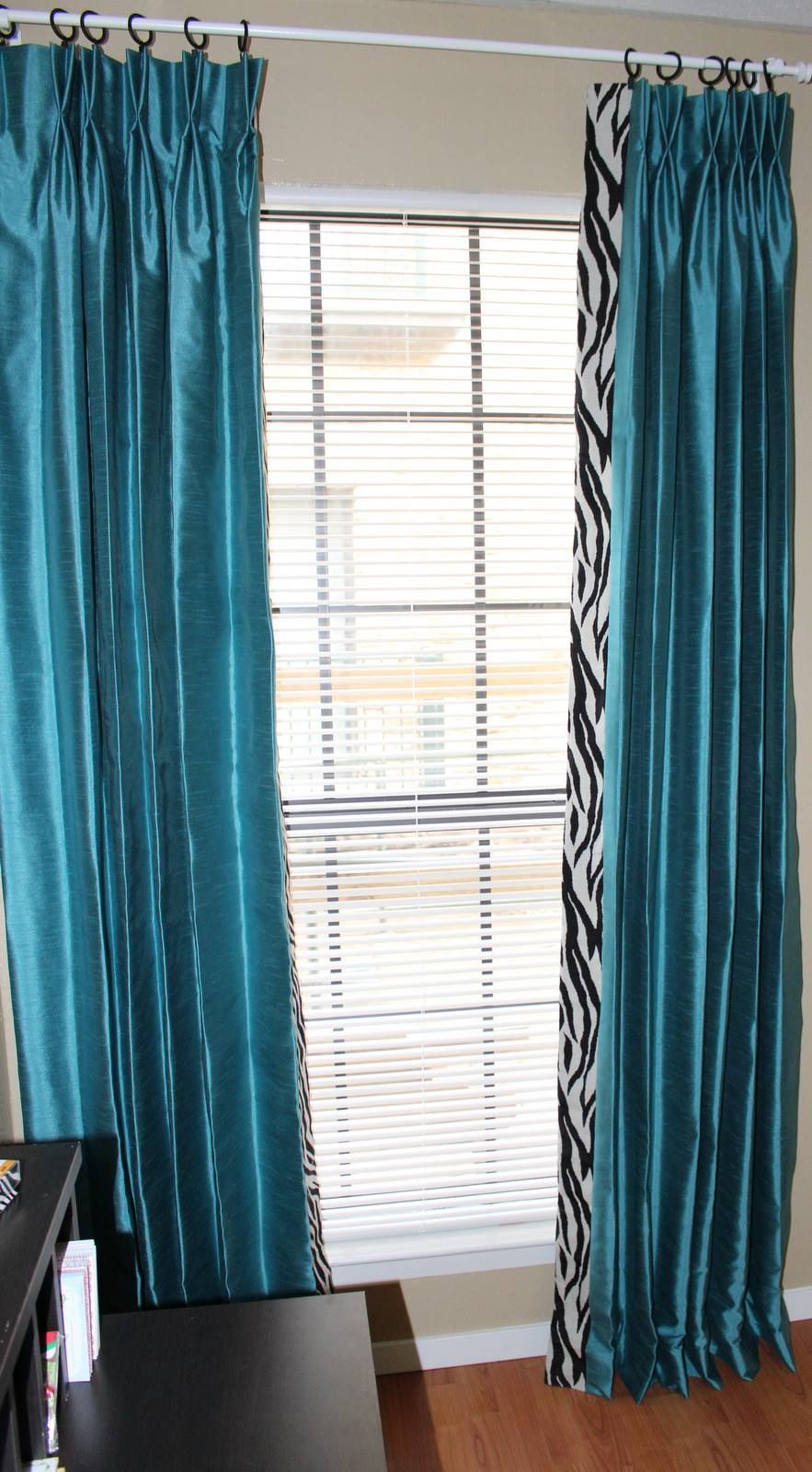 A pair of blue curtains are hanging on a window in a room.