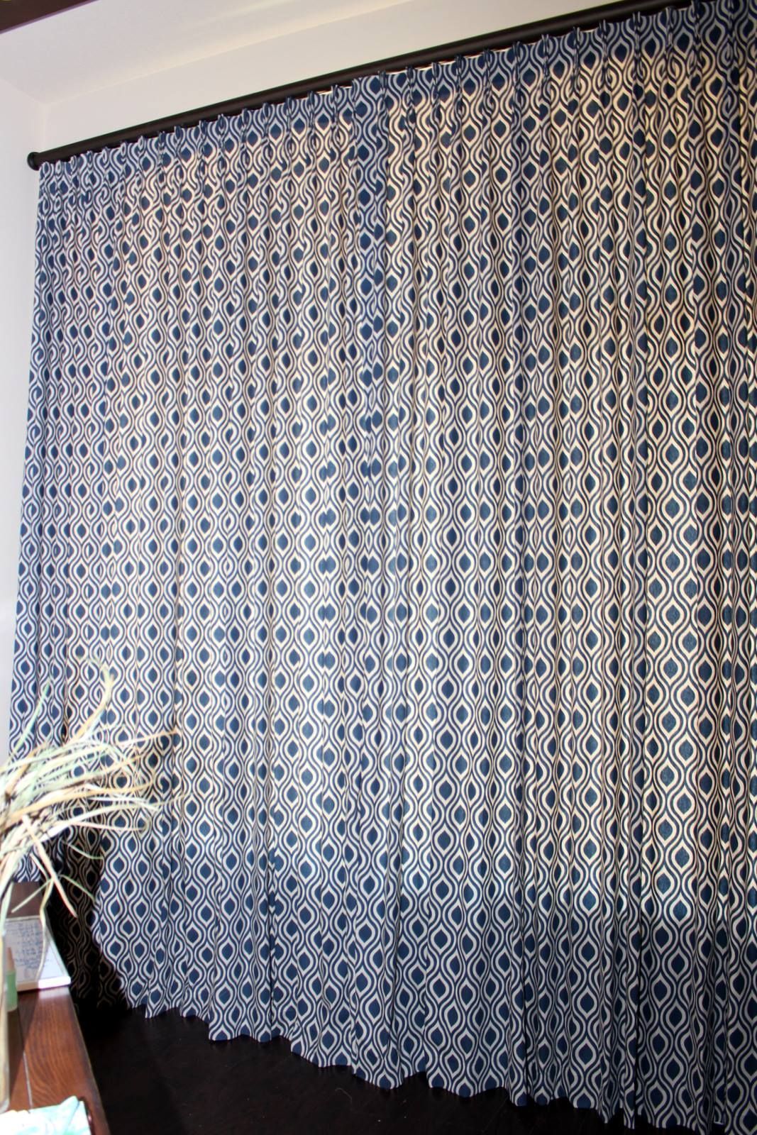 A curtain with a pattern on it is hanging on a wall in a room.