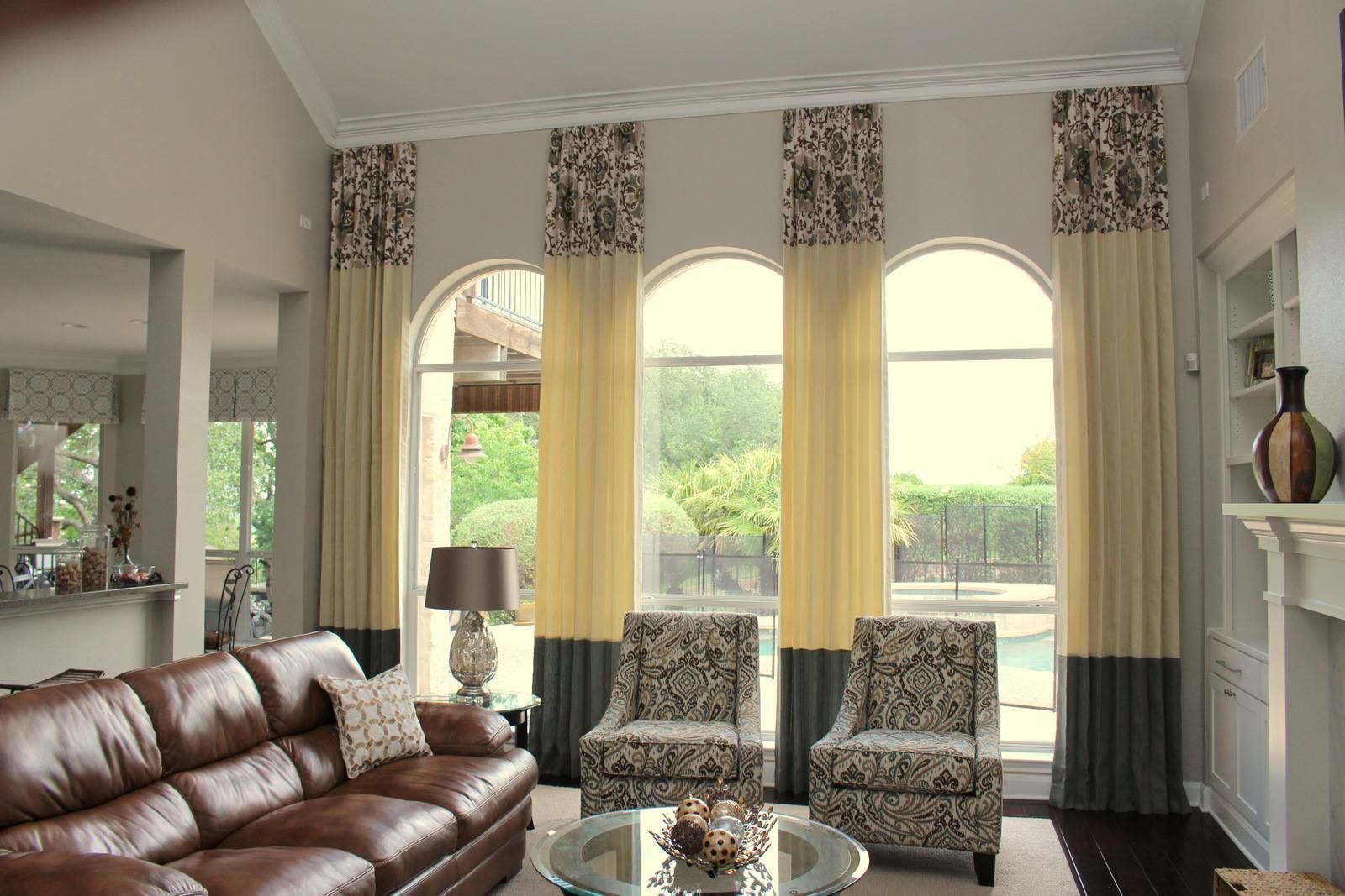 A living room with a brown leather couch and chairs