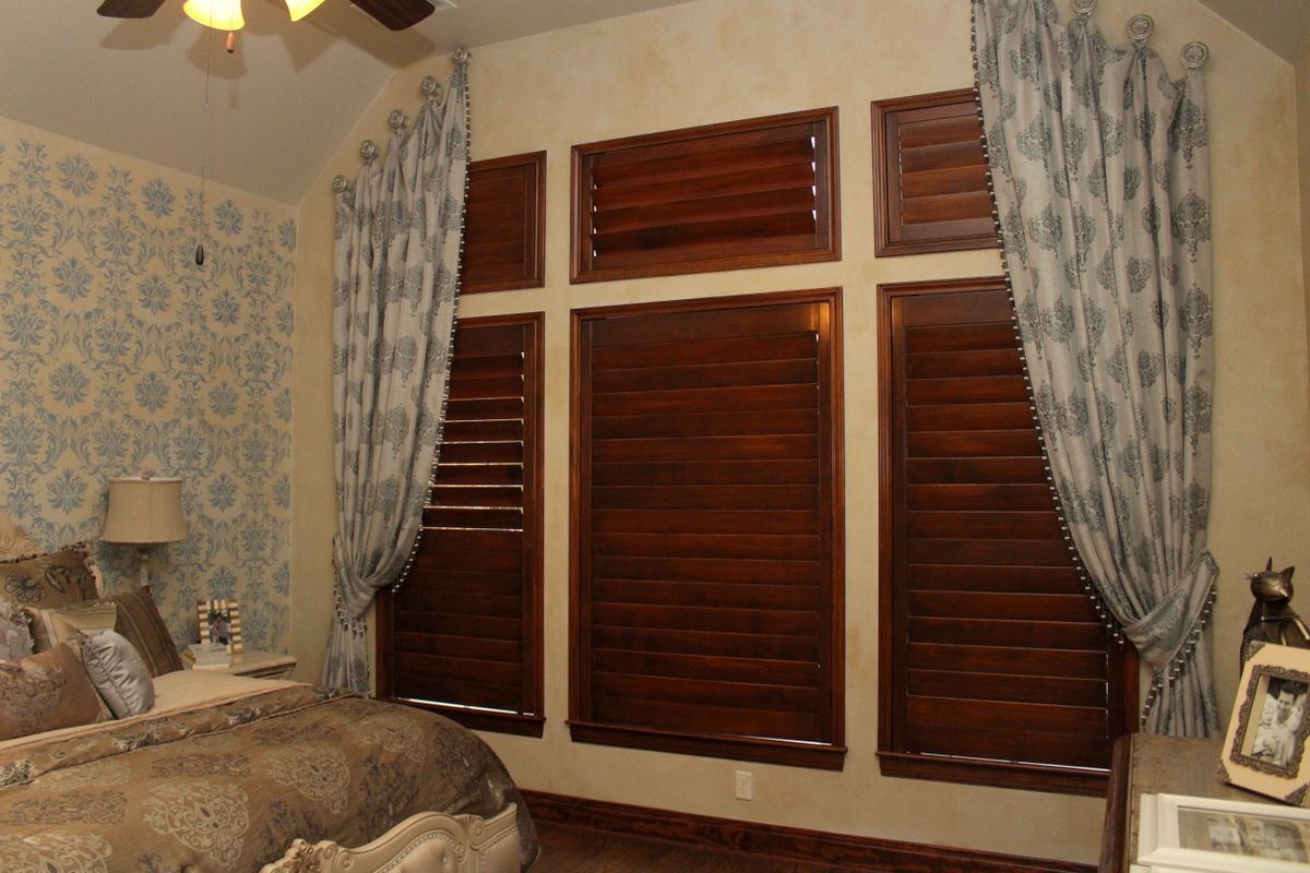 A bedroom with a bed and a ceiling fan