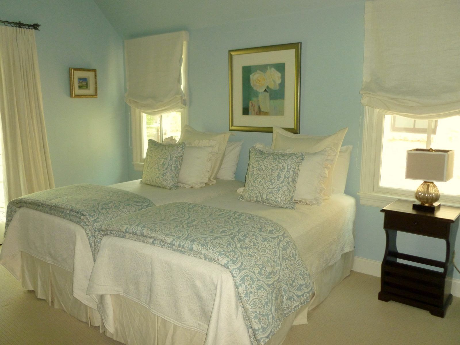 A bedroom with two beds and a nightstand