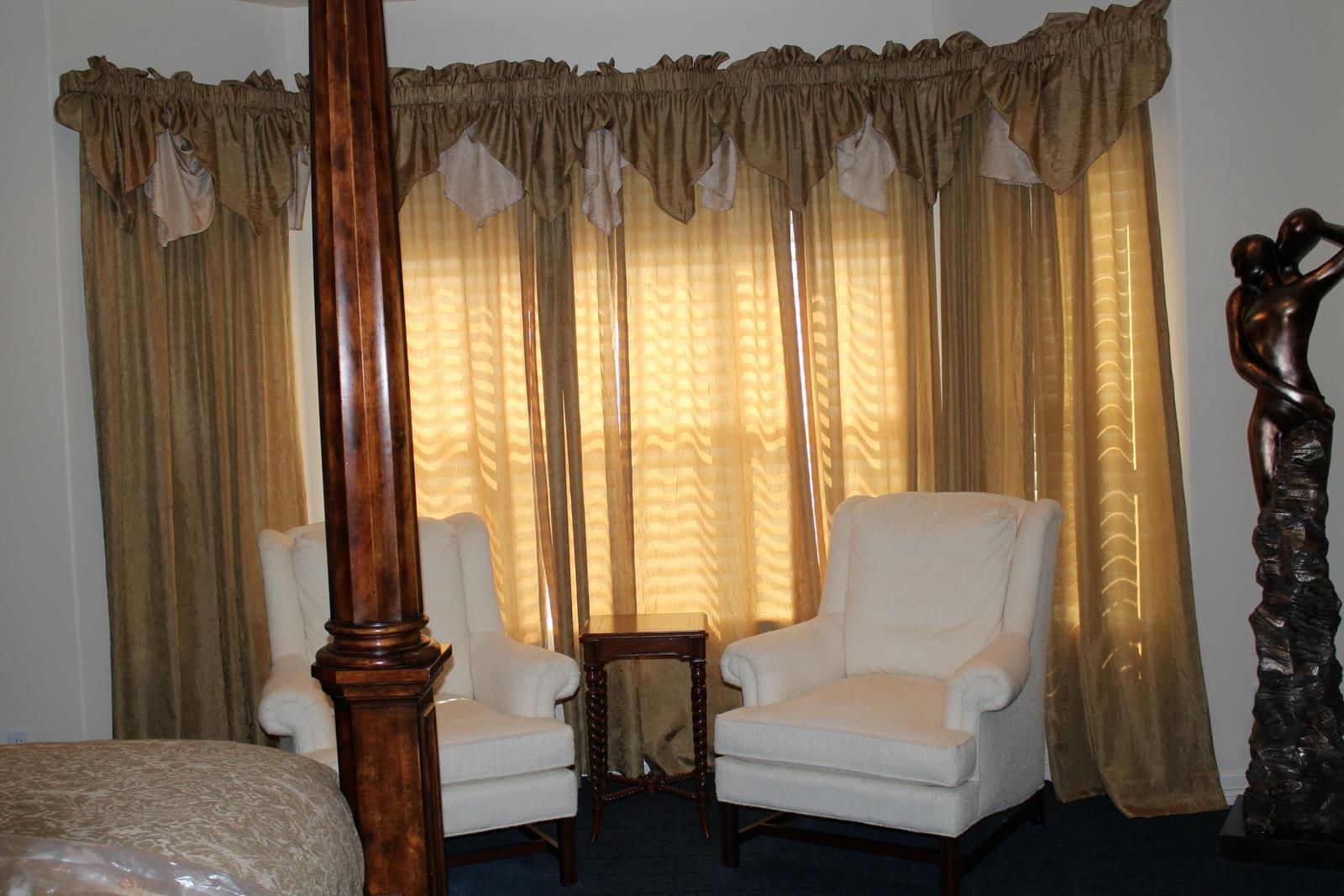 A bedroom with a four poster bed and two chairs