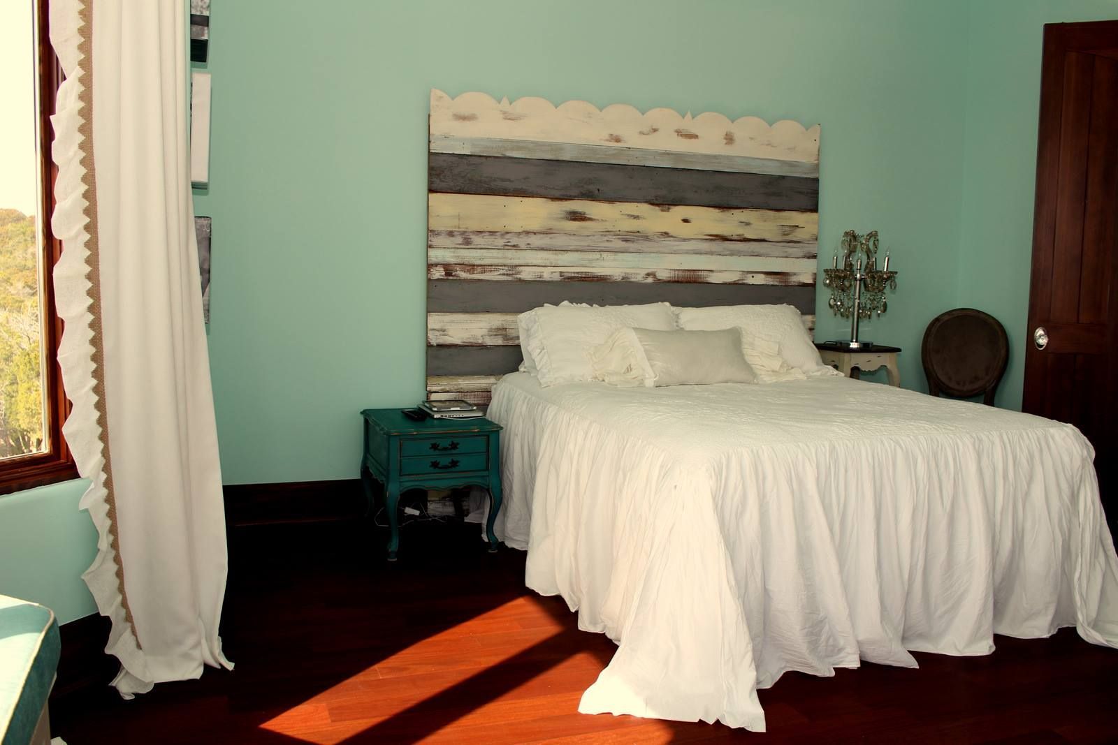 A bedroom with a bed and a wooden headboard