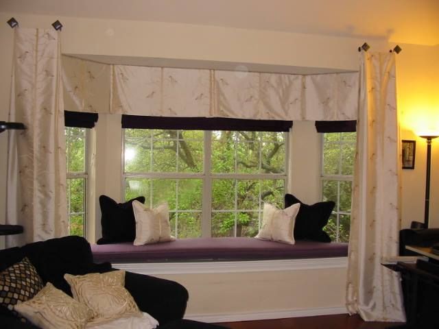 A living room with a window seat and curtains