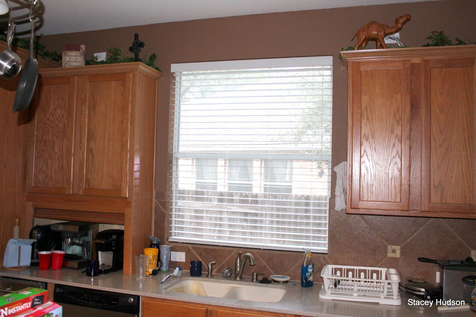 A kitchen with a sink and a window with blinds